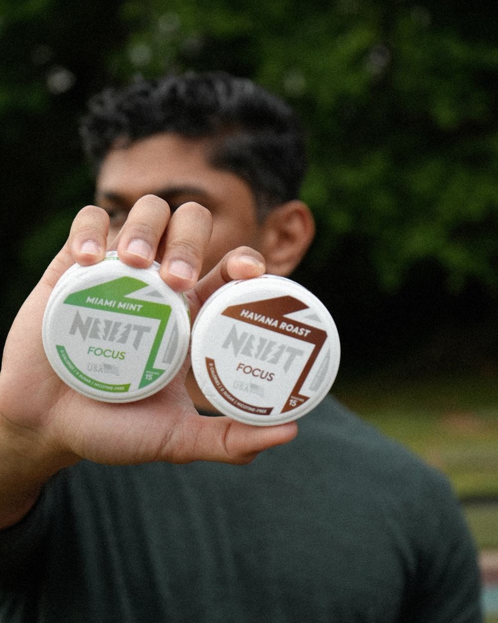 Hand holding a Miami Mint and a Havana Roast tin